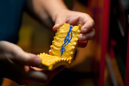 making jewelry, hands holding molds for casting golden jewelry parts