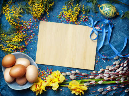 Easter empty background with Easter eggs and spring flowers. Top view with copy space.