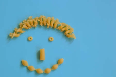 creative food concept, cute face with smile made from and italian pasta, top viewの写真素材