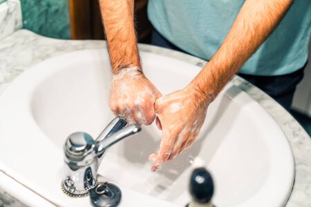 Washing your thumb thoroughly with disinfectant soap in the sink to prevent coronavirus infection. Washing your hands.の写真素材
