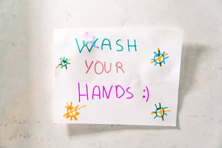 Drawing made by a child to remind him to wash his hands well to prevent coronavirus hanging in the bathroom. Wash your hands.の写真素材