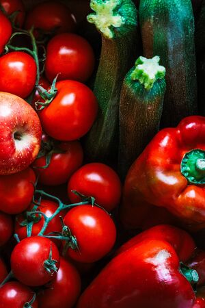 A set of very appetizing raw fruits and vegetables. Set of tomatoes, apples, peppers and zucchini. Red and green fruits and vegetables.の写真素材