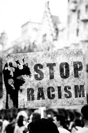 Stop racism. African american protester holding up a poster with a powerful anti-racism message.の写真素材