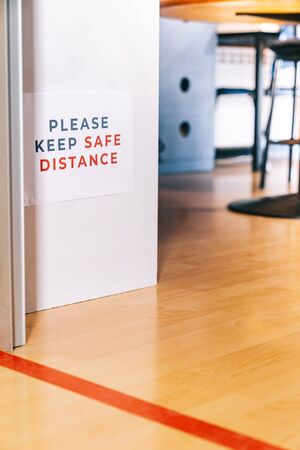 Please keep safe distance. Waiting behind a red line to enter a classroom. Social distancing measures for the reopening and adaptation of schools and academies to the new normal.の写真素材