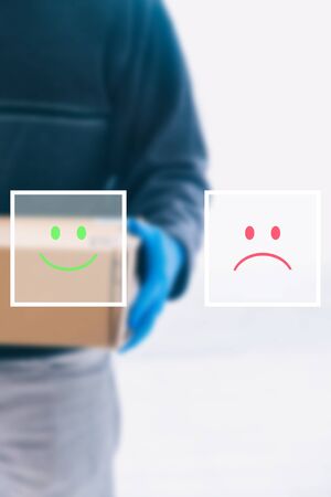 Concept of service rating and satisfaction with package delivery service. Design of emoticon faces of satisfied or dissatisfied customers.の写真素材