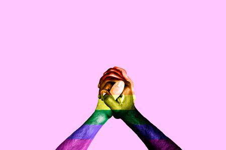 Multicultural hands united with the rainbow colors of gay pride. The LGBT rights movement and the concept of gender equalityの写真素材