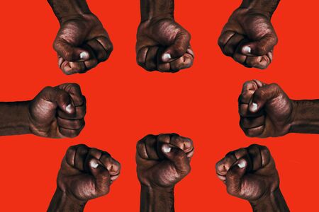 United african black fists raised calling for freedom and equality on a red background.の写真素材