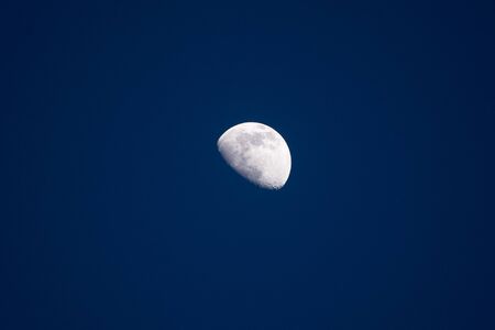 Close up of nice crescent moon on a dark blue sky. Stock photo of the details of the moon in the blue hour.の写真素材