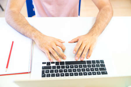 Young student typing on her laptop's keyboard doing her homework. Concept of distance education through the Internet.の写真素材