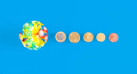 Top view of virus with different coins and money on a blue background. Covid-19 crisis. Economic crisis caused by coronavirus.の写真素材