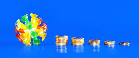 Isolated virus with different coins on a blue background. Covid-19 crisis money decreasing value. Economic crisis caused by coronavirus.の写真素材