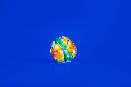 Multicolor virus isolated on a blue background. Toy recreation of covid-19 coronavirus.の写真素材