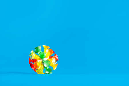 Multicolor virus isolated on a blue background. Toy recreation of covid-19 coronavirus with copy space.の写真素材