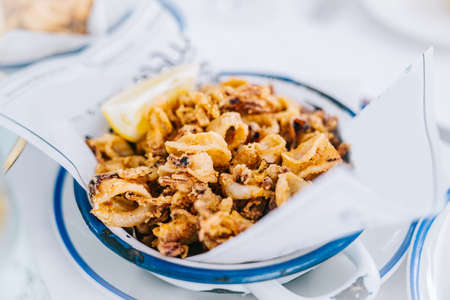 Fried squid on a plate in a restaurant. Typical recipe from Spain. Andalusian Calamari Tapa