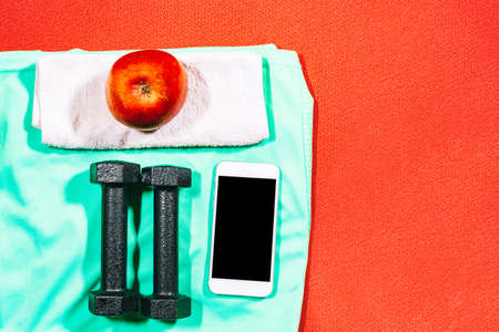Attributes of a healthy lifestyle: food, sport equipment, mobile phone. Tools for fitness at home.の写真素材