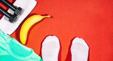 Set of sport attributes with feet of a person doing fitness at home.の写真素材