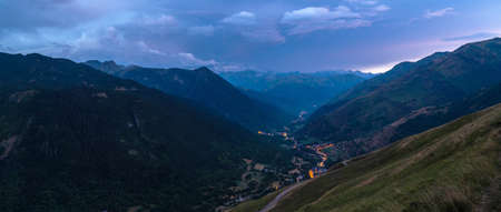 Valley with small typical mountain villages in the background illuminated with the lights of the streetlights at sunset. Panoramic view of the Aran Valley, Vaqueira, Beret, SalardÃº, LÃ©rida, Catalonia, Spain.の写真素材