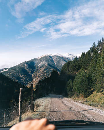 Route by car in the mountain. Forest track. Weekend getaways and rural tourism in the outdoors.