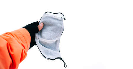 Hand holding a medical face mask in a white background for copy space. Concept of covid-19 pandemic...