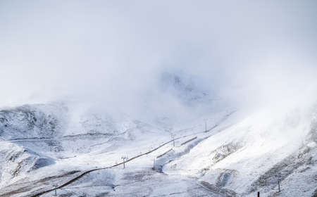 Snowy valley with some mountains and chairlifts in the background. Go skiing in the winter season....
