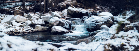 Mountain river with winter white snowy landscape. Winter, cold or Christmas landscape. Beautiful stream with flowing water, panoramic view.の写真素材