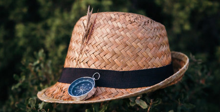 Straw hat with a compass on a natural background. Concept of traveling, traveling to nature, vacation and summer.の写真素材