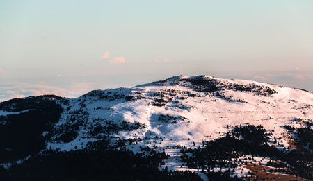 Snowy mountain white peak at sunrise. Calm and relaxing nature mountainous natural scenery. Nature background landscape with clear sky on early morning in the mountains.の写真素材