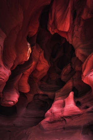 Amazing sandstone formations inside a cave in Coves De Can Riera caves in Torrelles, Barcelona, Catalonia, Spain. Vibrant red colors of eroded rock with wave forms similar to famous Grand Canyon, USA.の写真素材