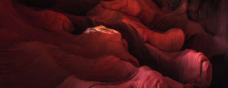 Amazing sandstone formations inside a caves in famous Grand Canyon and Antelope Canyon, USA. Vibrant red colors of eroded rock. Abstract wave forms texture.の写真素材