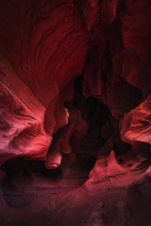 Amazing sandstone formations inside a cave in Coves De Can Riera caves in Torrelles, Barcelona, Catalonia, Spain. Vibrant red colors of eroded rock with wave forms similar to famous Grand Canyon, USA.の写真素材