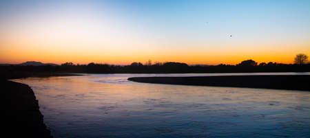 Mouth of the river Ter in the Mediterranean Sea. Panoramic landscape of sunset or sunrise on a river. Natural river flowing calmly.の写真素材