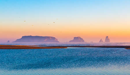 Mouth of the river Ter in the Mediterranean Sea with the Medes Islands and Estartit in the background. Panoramic sunrise landscape with the river flowing calmly. Morning lights with calm atmosphere.の写真素材