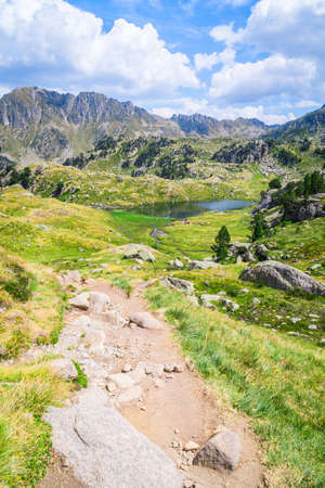 Mountainous landscape with beautiful green mountains and a lake on a sunny day. Concept of mountain trip and summer vacations. Circo Saboredo, Aran Valley-Pyrenees, Catalonia, Spain.の写真素材