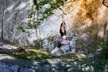 Young girl in mountains doing yoga exercise outdoorの写真素材