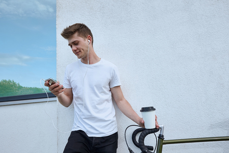 Handsome hipster man posing with bicycle in the city.の写真素材