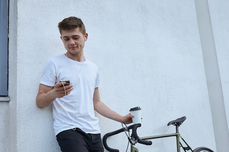 Handsome hipster man posing with bicycle in the city.の写真素材