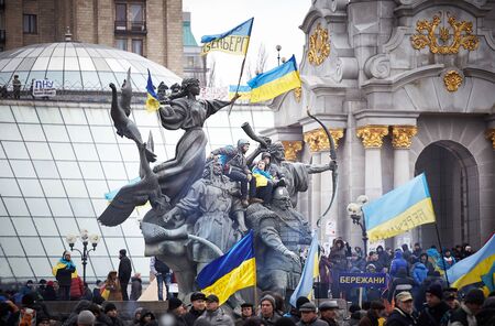 People sit on the monument decorated with flags during revolution in the Ukraineのeditorial素材