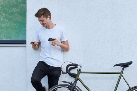 Handsome hipster man posing with bicycle in the city.の写真素材
