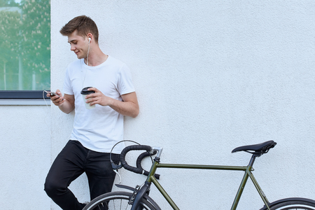 Handsome hipster man posing with bicycle in the city.の写真素材