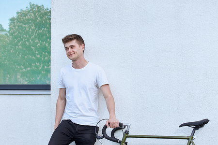 Handsome hipster man posing with bicycle in the city.の写真素材