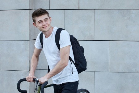 Handsome hipster man posing with bicycle in the city.の写真素材