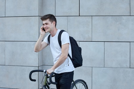 Handsome hipster man posing with bicycle in the city.の写真素材