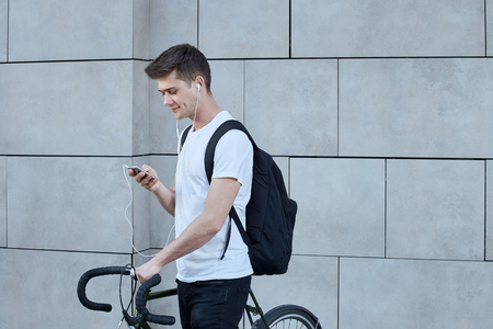 Handsome hipster man posing with bicycle in the city.の写真素材
