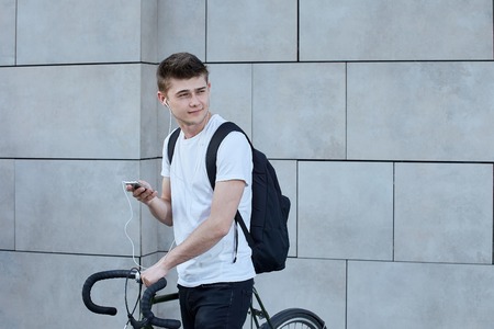 Handsome hipster man posing with bicycle in the city.の写真素材
