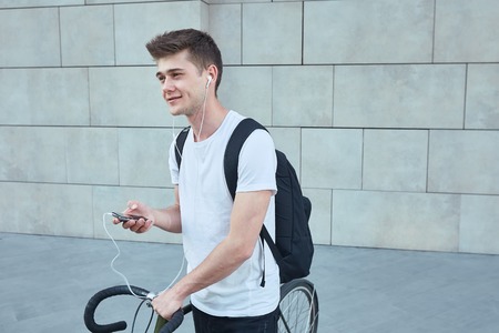 Handsome hipster man posing with bicycle in the city.の写真素材