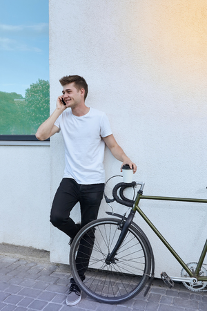 Handsome hipster man posing with bicycle in the city.の写真素材