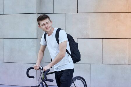 Handsome hipster man posing with bicycle in the city.の写真素材