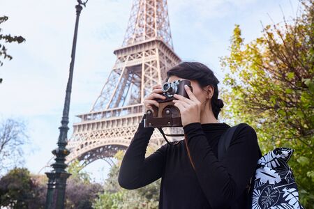 Beautiful girl posing with a camera on the background of the Eiffel Tower. Paris, Champ de Marsの写真素材