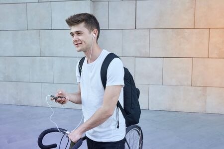 Handsome hipster man posing with bicycle in the city.の写真素材