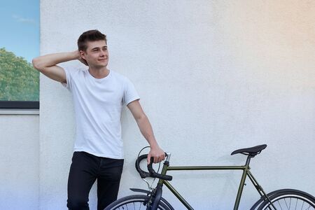 Handsome hipster man posing with bicycle in the city.の写真素材